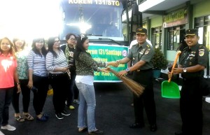 Kolonel Ario menyerahkan alat bersih bersih kepada Ketua FJPI Sulut Jeane Rondonuwu
